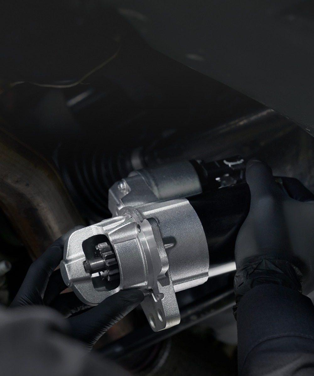 Técnico cambiando pieza mecánica en la parte inferior de un vehículo